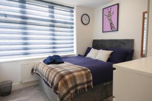 a bedroom with a bed and a clock on the wall at Star London Bell Lane 3-Bed Haven in Hendon