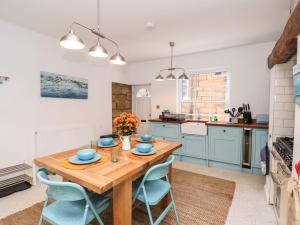 a kitchen with a wooden table and blue cabinets at Navigators Rest in Whitby