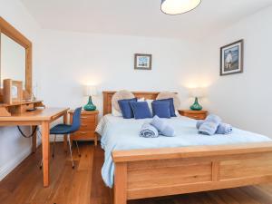 a bedroom with a bed with blue pillows and a desk at Navigators Rest in Whitby