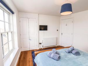 a bedroom with a blue bed with towels on it at Navigators Rest in Whitby