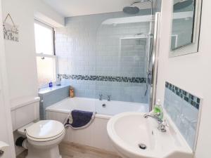 a bathroom with a tub and a toilet and a sink at Navigators Rest in Whitby
