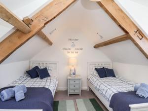 two beds in a attic bedroom with wooden beams at Navigators Rest in Whitby