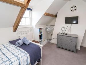 a bedroom with a bed and a tv on the wall at Navigators Rest in Whitby