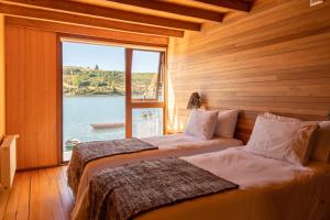 2 camas en una habitación con vistas al agua en Sizigia, en Castro