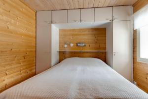 a bedroom with a bed in a room with wooden walls at Tapola in Kalajoki