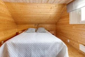 ein Schlafzimmer mit einem Bett in einer Holzhütte in der Unterkunft Tapola in Kalajoki
