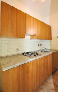 una cucina con armadi in legno e piano cottura. di Condominio Aurora a Bibione