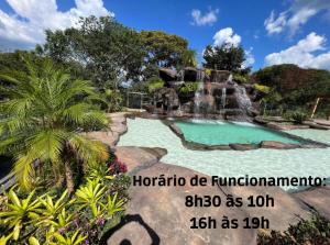 einen Pool mit Wasserfall im Hof in der Unterkunft Pousada do Batata in Capitólio