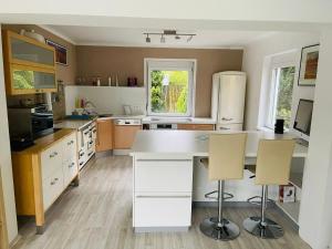 a kitchen with a white counter and two chairs at APARTMENT Schlossbergblick in Griffen