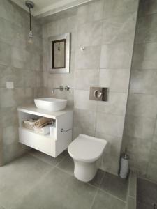 a bathroom with a white toilet and a sink at Chatzidakis Apartment/Inspiration harmony in Lygaria