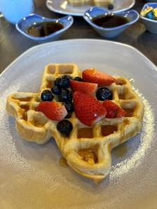 a waffle with strawberries and blueberries on a plate at Dallas/Plano Marriott at Legacy Town Center in Plano