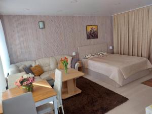 una camera con letto, divano e tavolo di Nida guesthouse at Loreta a Nida