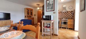 a living room with a table and a kitchen at Ai Grisi in Cavalese