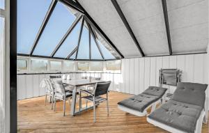 a dining room with a table and chairs and windows at Holiday Home Fanø 46 in Fanø