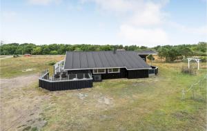 a house with a black roof in a field at 3 Bedroom Gorgeous Home In Fan in Fanø