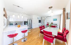 een keuken en eetkamer met een tafel en rode stoelen bij 4 Bedroom Amazing Home In Kastel Gomilica in Kaštela