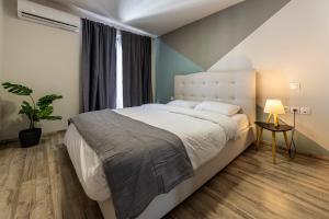 アテネにあるAthenian boutique apartmentsの大きなベッドと窓のある寝室