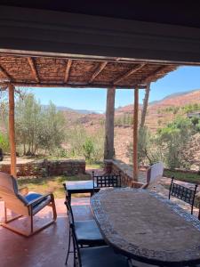 a patio with a table and chairs and a view at Les Hortensias in Bine el Ouidane