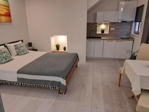 1 dormitorio con 1 cama grande y cocina en LUCIANA, en Korčula