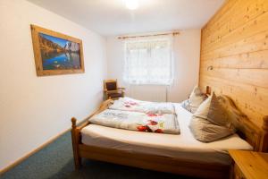 Schlafzimmer mit einem Bett mit einem Kopfteil aus Holz in der Unterkunft Appartementhaus Untere Tanne in Lermoos