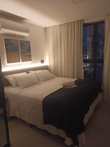 a bedroom with a large bed with a window at Loft aconchegante à Beira-Mar in João Pessoa
