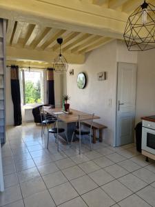 a kitchen and dining room with a table and chairs at L’Atelier de la Forge L’enclume in Martigny-le-Comte