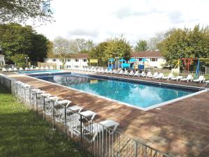 a swimming pool with chairs and a playground at 2 bed Villa with full use of site facilities in Newquay