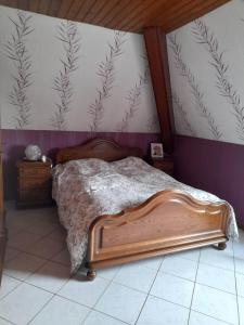 um quarto com uma cama de madeira e uma parede com papel de parede em Gîte Le Jardin de Hermolsheim. Alsace très spacieux em Mutzig