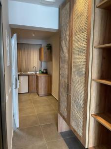 uma cozinha com um corredor que leva a uma cozinha com armários de madeira em SunBeam em Kardamaina