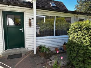 een groene deur op een wit huis met planten bij Gästehaus in Senzig
