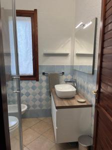 ein Badezimmer mit Waschbecken, Toilette und Spiegel in der Unterkunft Casa Stewart - Levante in Geremèas + 50 Fotos