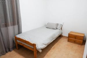 a small bedroom with a bed and a night stand at Xalet en Riumar,Delta del Ebro in Riumar