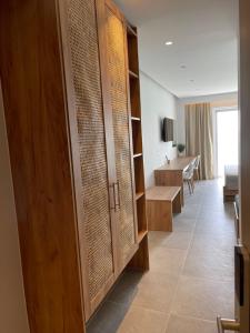 Pokój z drewnianymi szafkami i salonem w obiekcie SunBeam w Kardamenie