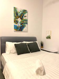 a bed in a bedroom with a painting on the wall at Casa Le Oasis (13A) in Kuah