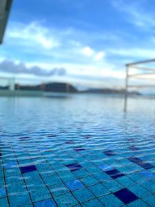una piscina con azulejos azules en el agua en Casa Le Oasis (13A), en Kuah