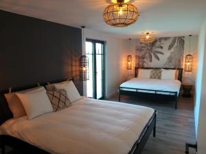 a bedroom with two beds and a chandelier at Landhuys Odette in Retie +37 photos