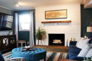 a living room with a blue couch and a fireplace at 1908 Modern Farmhouse on large private treed lot in Shawnee