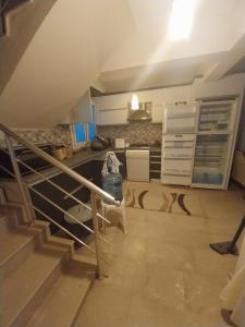 a kitchen with a staircase leading up to a loft at Arko sitesi in Karaburun