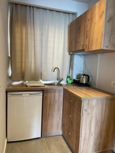 a small kitchen with wooden cabinets and a sink at SunBeam in Kardamaina
