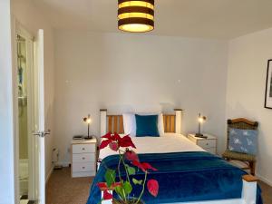 1 dormitorio con 1 cama con edredón azul en Jersey Villa Guest House en Warwick