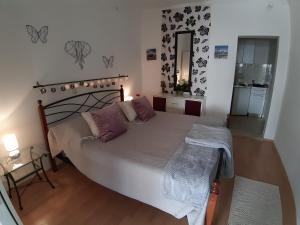 a bedroom with a large white bed with purple pillows at Villa Tania in Hvar