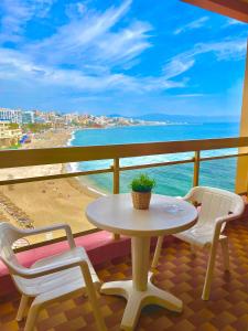 a table and chairs on a balcony with a view of the beach at Sunset Beach Benalmadena in Benalmádena
