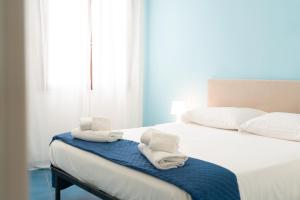 sypialnia z dwoma białymi ręcznikami na łóżku w obiekcie Elimi Favignana Apartments - Residence in città w mieście Favignana