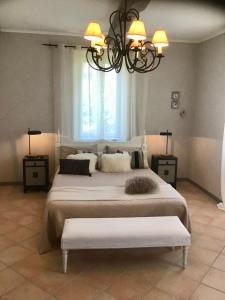 a bedroom with two beds and a chandelier at Maison En Cramaillan in Bragayrac