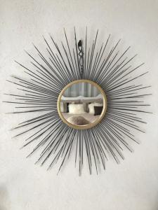 a sunburst mirror hanging on a wall at Maison En Cramaillan in Bragayrac