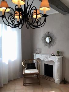 a chandelier in a living room with a fireplace at Maison En Cramaillan in Bragayrac