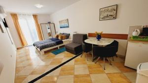 cocina y sala de estar con mesa y sillas en Apartments Anita, en Opatija