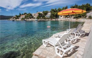 two lounge chairs and an umbrella in the water at Stunning Home In Klek With Sauna in Klek