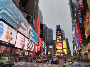 una concurrida calle de la ciudad con coches, personas y edificios en Pestana CR7 Times Square, en Nueva York