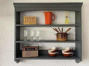 a shelf with a radio and cups on it at Chez Edgar in Thollon